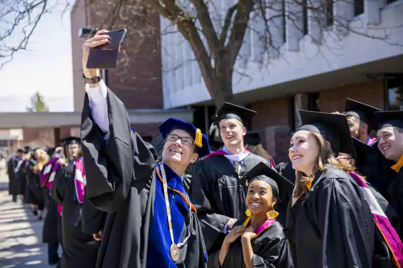Alma College President Jeff Abernathy takes a selfie with 2019 Alma graduates