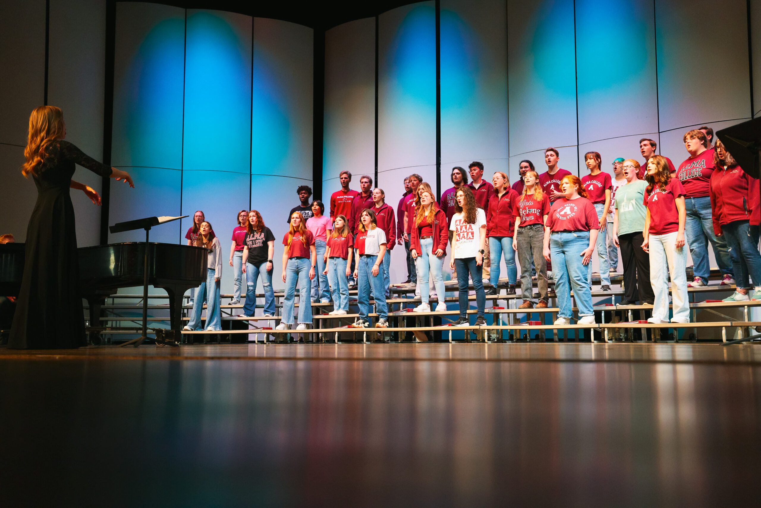 Large group of Alma College Student on stage at the Alumni Awards dressed in Alma gear.