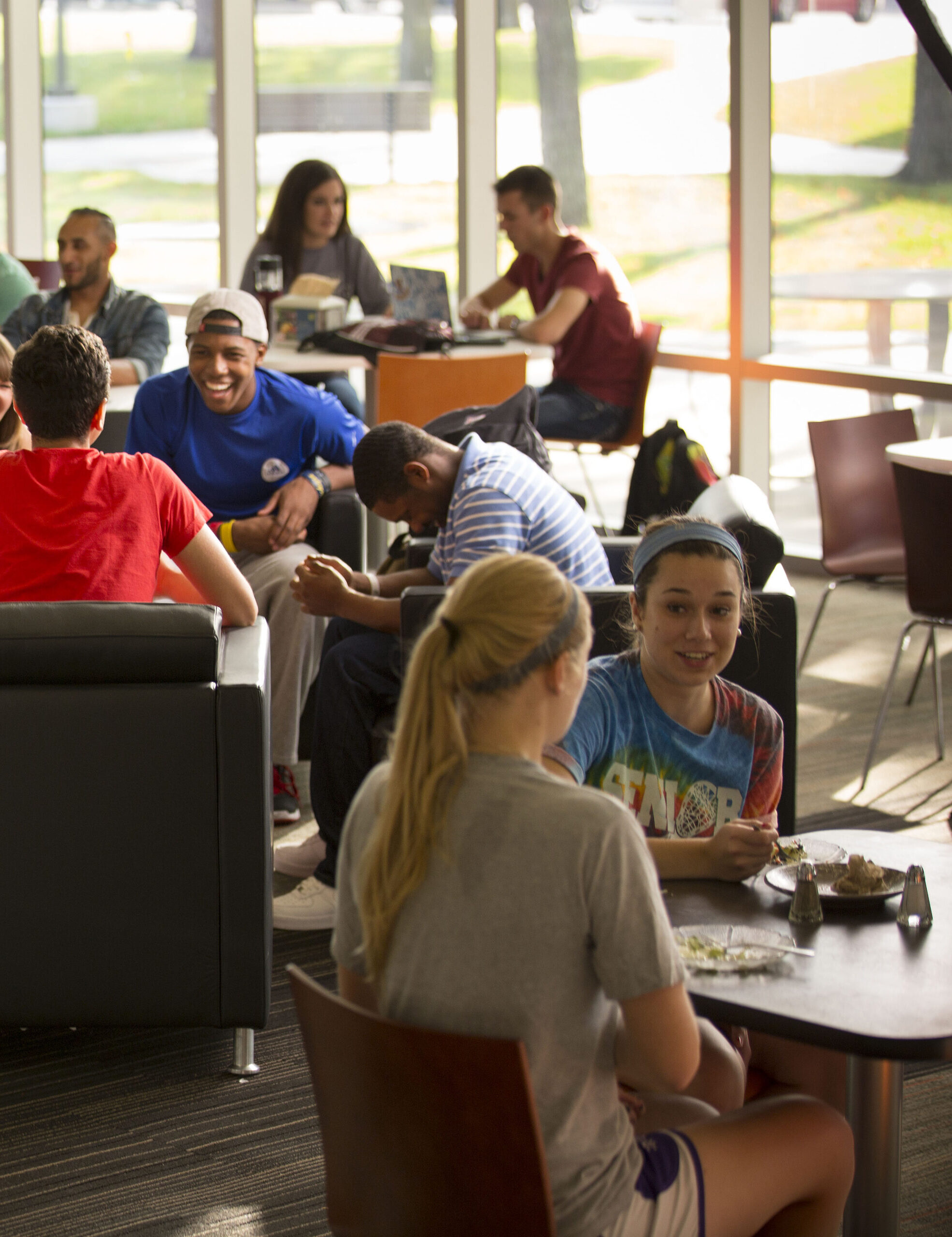 Students in groups, eating and talking inside Hamilton Commons Dining Lounge