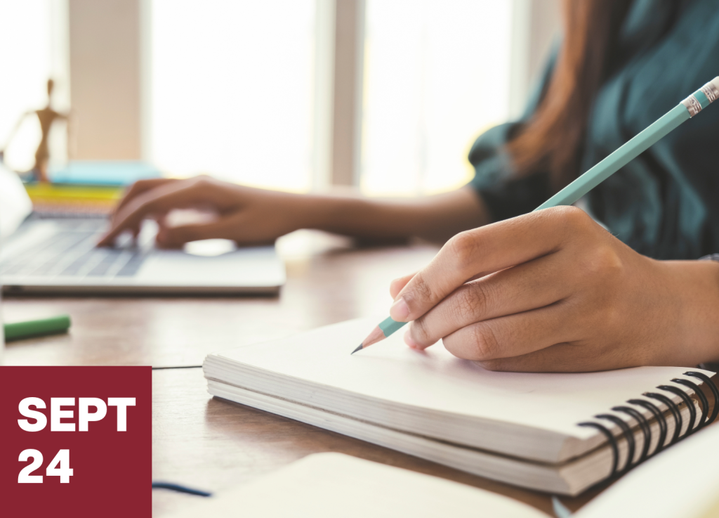 A person writes in a notebook with a pencil beside an open laptop, perhaps jotting down ideas for their mfa-in-creative-writing. Sunlight streams through the windows. A red box in the corner displays SEPT 24 in white text.