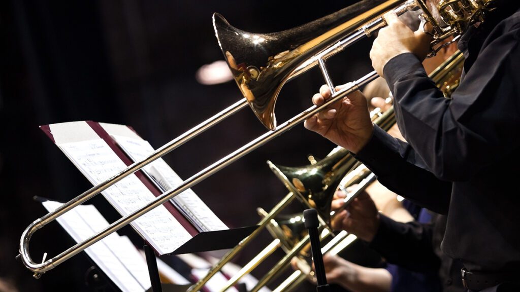 A musician passionately playing the trombone as part of a vibrant band performance.