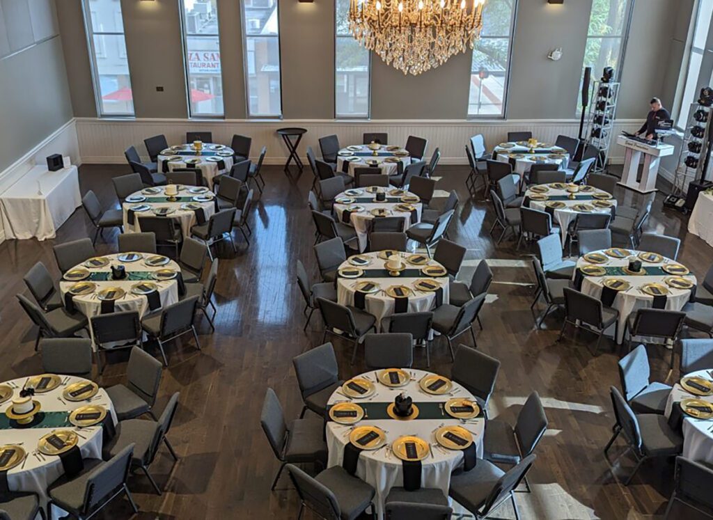 Round tables are set up in the Alma College Opera House ballroom, ready for a wedding reception.