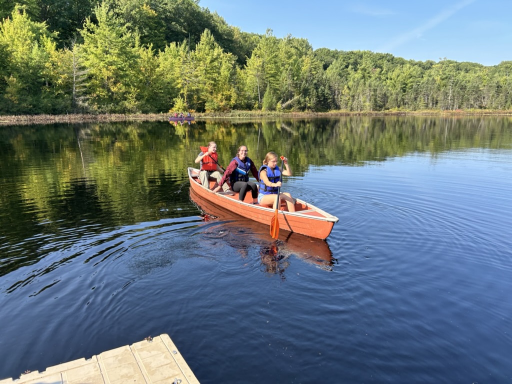 Alma College students canoe on a bog during a sunny day for their biology course.