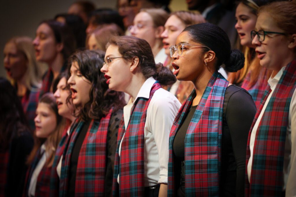 Festival of carols music show at the heritage center, women and men sining festive songs to a crowd.