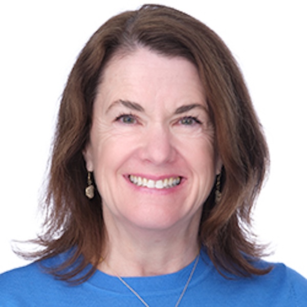 A middle-aged woman in a blue top, with medium-length, brown hair, poses for a photo.
