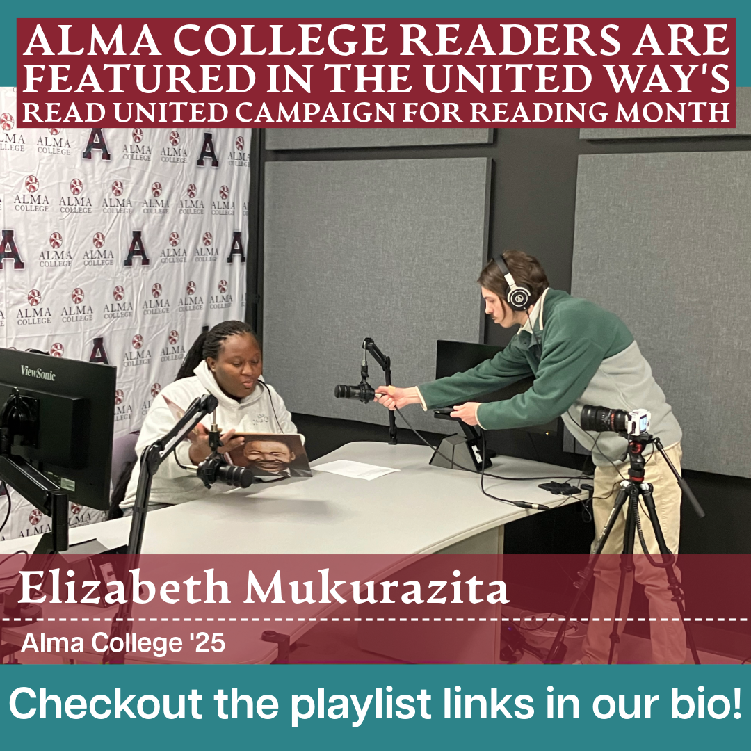 Alma College alumnus, Elizabeth Mukurazita reads a book at a table with podcast equipment.