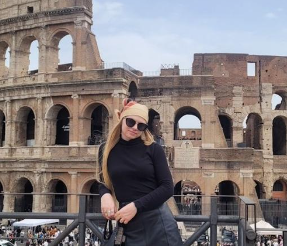 An Alma College students poses in front of a historical monument in Europe.