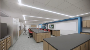 A modern science classroom or laboratory with wood cabinets, black countertops, red chairs, ceiling lights, a whiteboard, and a map on the wall. A person stands near the cabinets on the left.