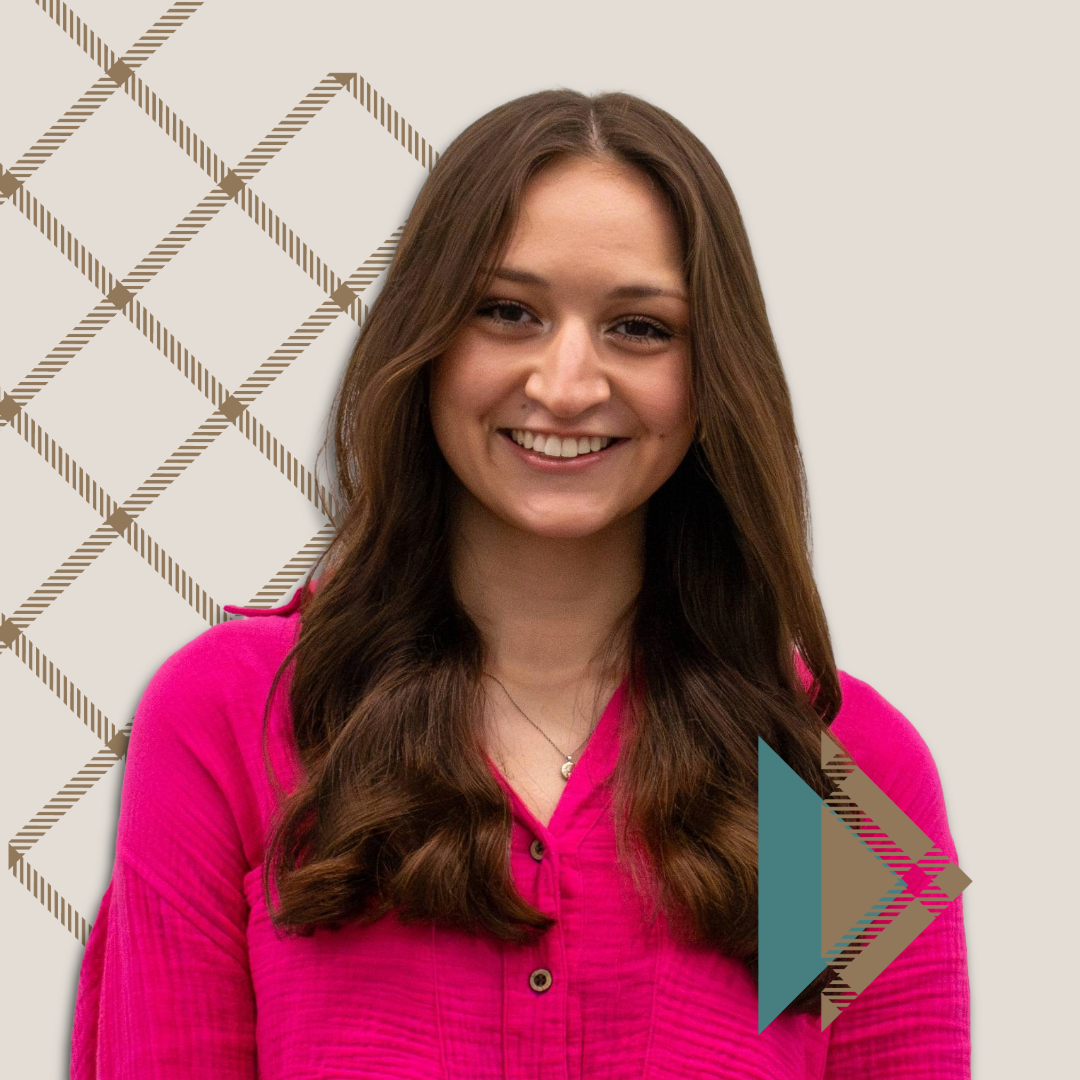 A woman with long brown hair wearing a bright pink blouse smiles at the camera, inviting you to connect with your admissions team. The background features geometric diagonal lines and a triangular, multicolored graphic in the lower right corner.