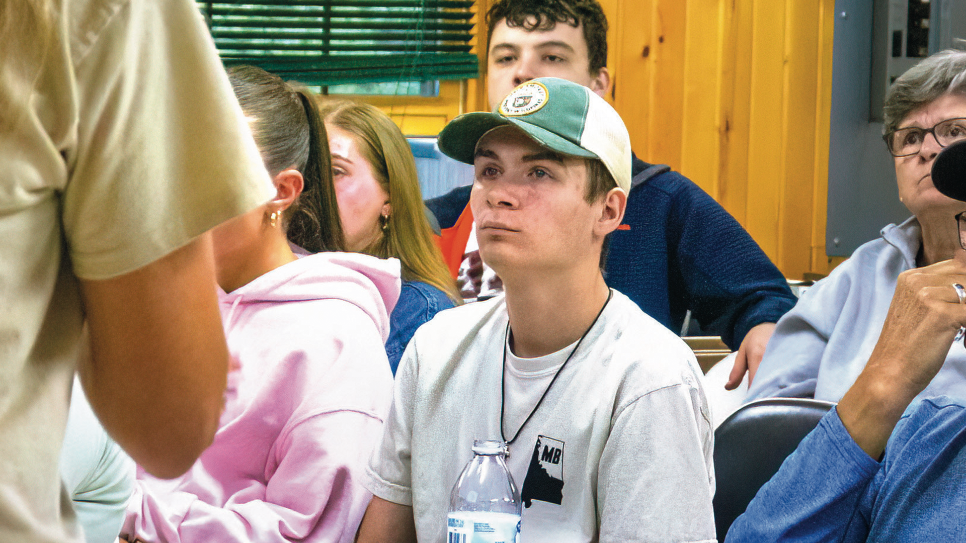 A group of biology students listening to a presentation on novel research in an indoor classroom.